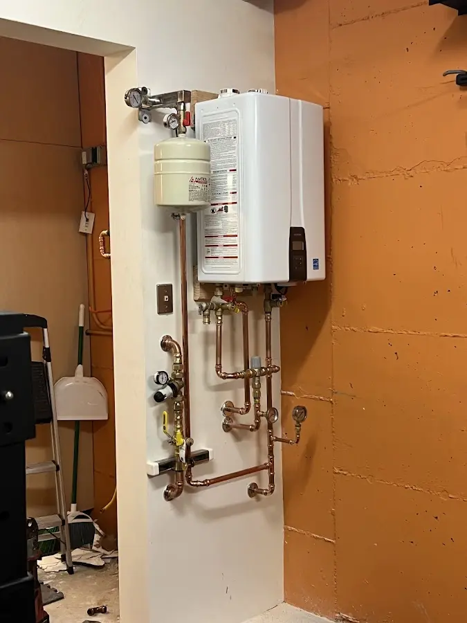 Plumbing technician inspecting water heater connections in Sugar Grove